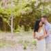 Couple hugging and kissing in a field of cherry blossoms at the Brooklyn Botanical Garden