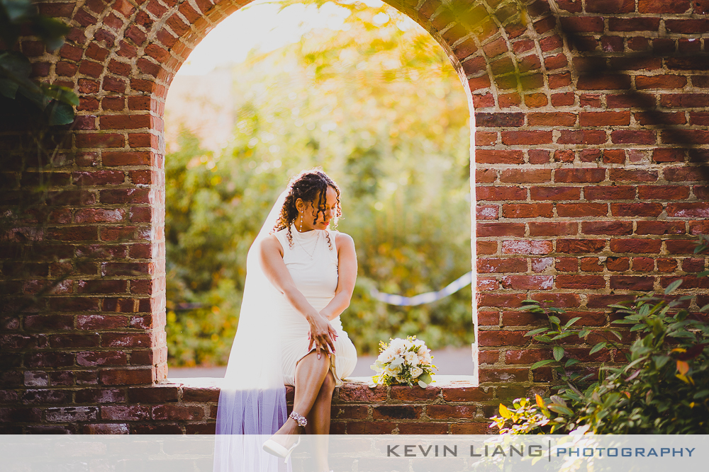 A stunning bride gracefully seated in a beautiful archway, radiating elegance and charm.