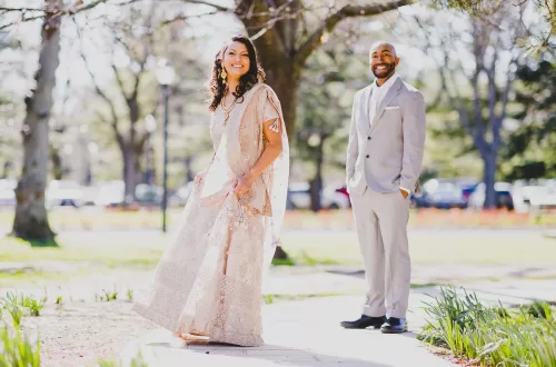 desi couple in a park in a traditional outfit and dancing on a path