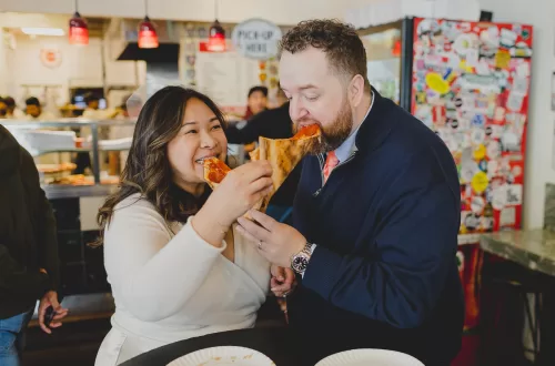 Couple feeding each other pizza