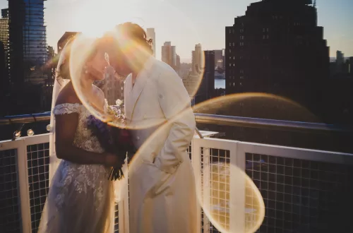 Same-Sex Lesbian Couple on rooftop pressing forehead together in the sunset
