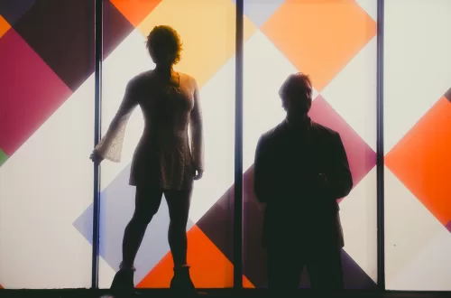 Silhouette of a couple in front of a checkered color pattern